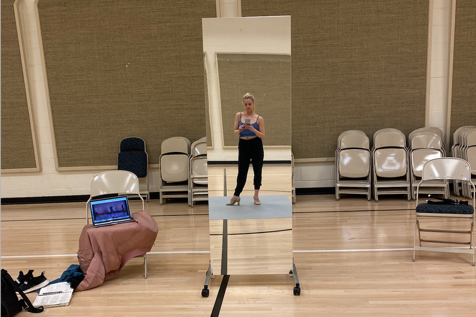 Hilton stand in front of a small full length mirror in the community center.